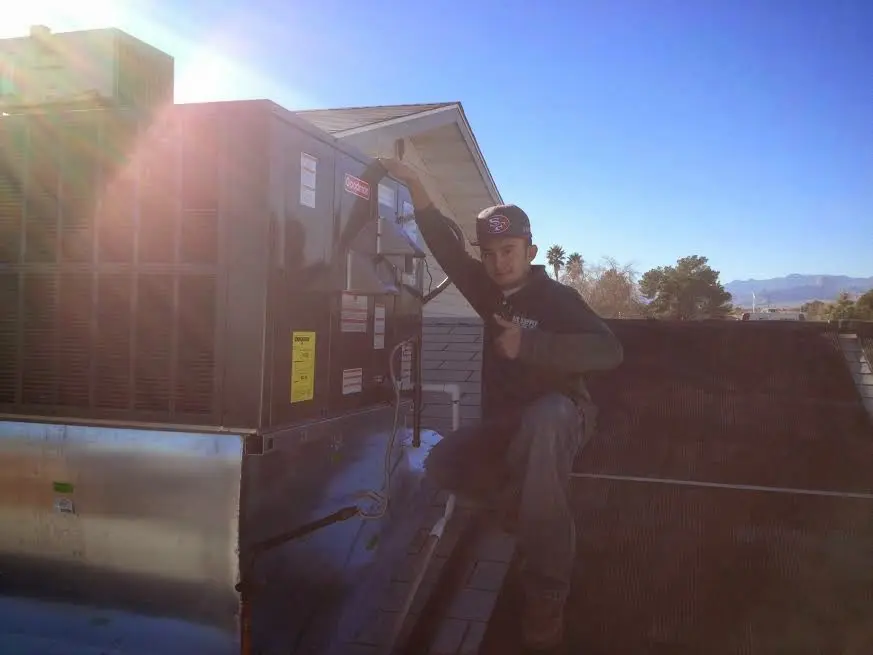 HVAC technician performing AC Tune-Up on a rooftop unit in Highland
